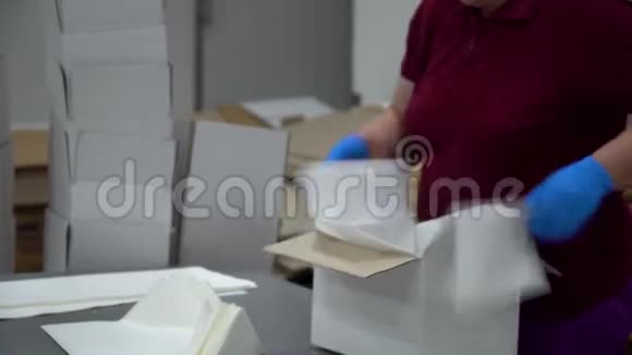 一位工厂女工把纸放在空盒子的中间放在传送带上视频的预览图