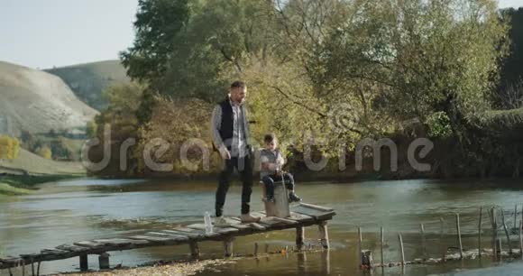在大自然中爸爸和他的儿子一起度过了一天钓鱼一起玩视频的预览图