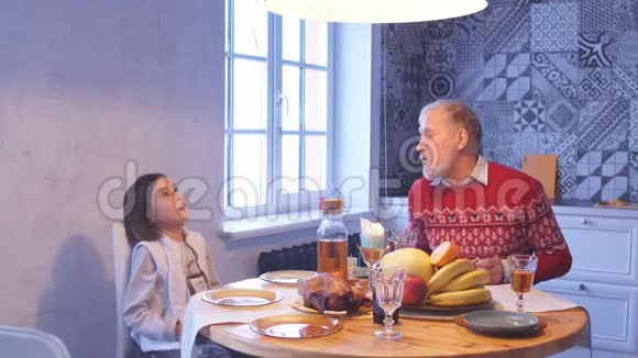 有个可爱女孩的老头正坐在桌边聊天视频的预览图