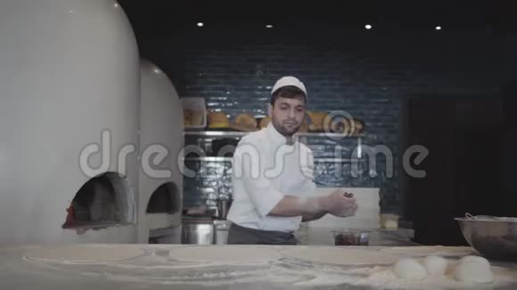 一位穿着白色制服的经验丰富的厨师准备了美味的烤肉串厨师把馅料放进面团里视频的预览图