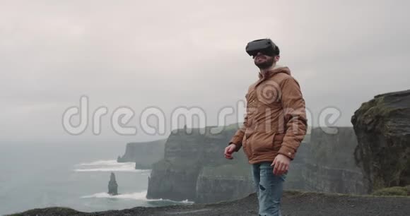 在悬崖顶上有一个虚拟现实的人他探索周围的风景他非常高兴的地方在顶部视频的预览图