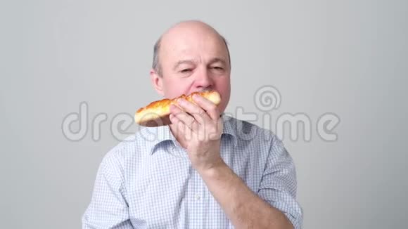 老人咬着白色背景的美味馅饼视频的预览图
