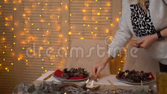 女人或女孩用手装饰圣诞或新年晚餐的桌子手把勺子和刀放在盘子附近视频的预览图