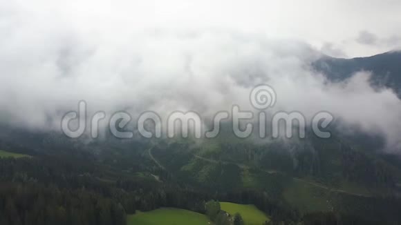 空中拍摄在云层中镜头越过青山和田野视频的预览图