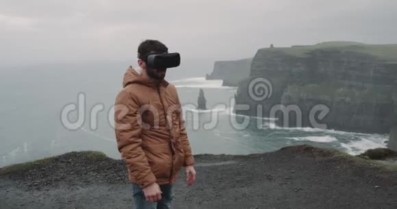 年轻的游客在旅行中使用虚拟现实他来到了悬崖顶部令人惊叹的地方并印象深刻地环顾四周视频的预览图