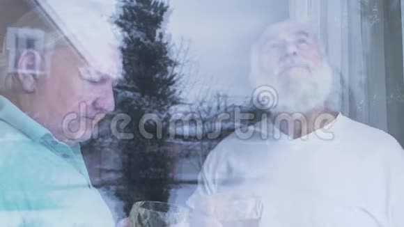 两个喝着酒精威士忌的老人站在家窗户附近白种人老人和朋友在享受时光视频的预览图