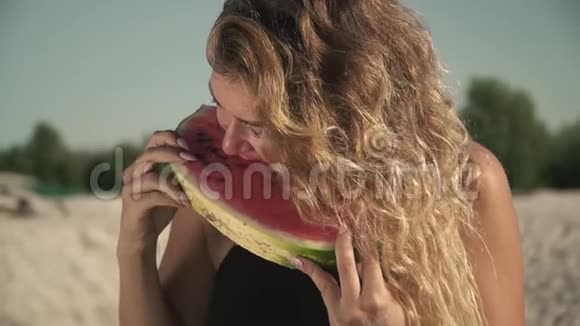 热辣的女人挥舞着头发在户外吃西瓜的肖像女孩享受着她的休息和微笑视频的预览图