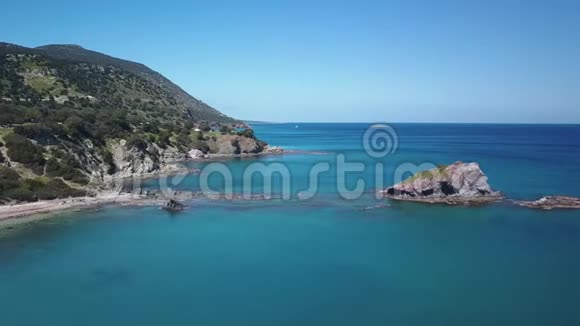 阳光明媚的一天温暖的海水在海岸的岩石附近惊人的蓝色水域鸟瞰视频的预览图