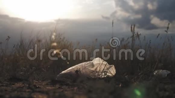 夕阳下草地上的白色塑料袋塑料污染的概念对地球的伤害视频的预览图