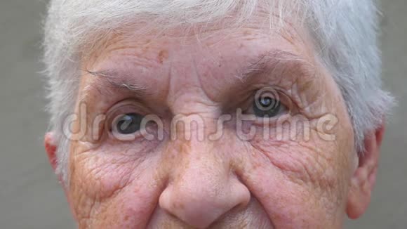 闭上祖母灰色的眼睛眼睛周围有皱纹一位老太太用视频的预览图