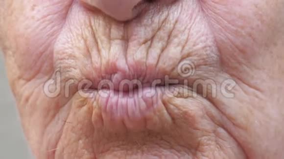 闭上老奶奶的嘴把空气吻进相机里一位皮肤皱巴巴的老女人做接吻动作视频的预览图
