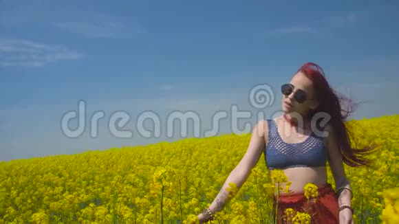年轻女子在科尔扎中心绽放的黄色田野随风起舞视频的预览图