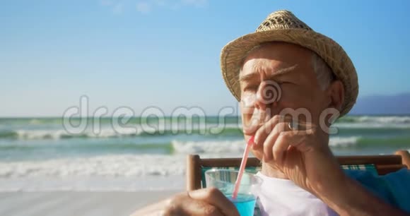活跃的高加索人在海滩上喝鸡尾酒的正面景色视频的预览图