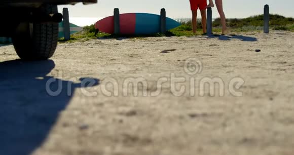 站在沙滩4k水泥柱子上的年轻女子视频的预览图