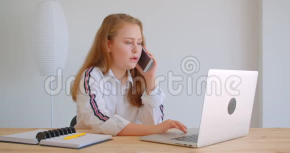 年轻漂亮的白种人女孩在室内使用笔记本电脑打电话的特写照片视频的预览图