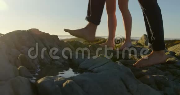 一对夫妇在海滩上的岩石上行走4k视频的预览图