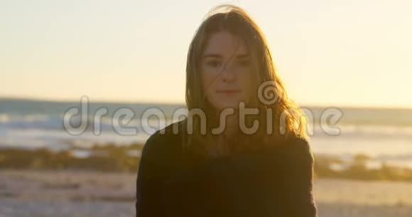 日落时海滩上美丽的年轻女子肖像视频的预览图