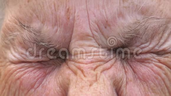 成熟女人的肖像弄乱她灰色的眼睛然后睁开把老奶奶满脸皱纹的脸贴紧视频的预览图