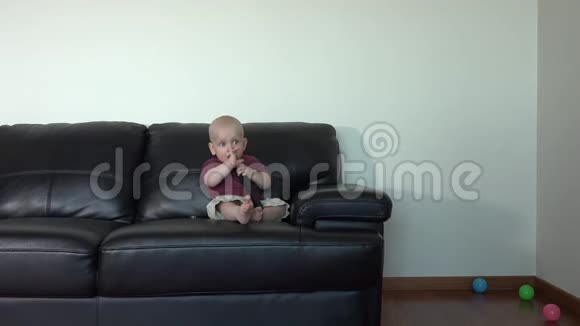 快乐微笑的幼儿男孩手拿遥控器看电视视频的预览图