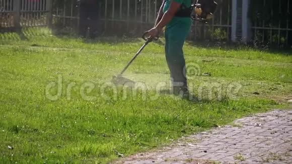 园艺工人在公园里用汽油割草机割草慢动作视频的预览图