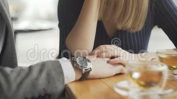 在咖啡馆牵手的年轻夫妇视频的预览图