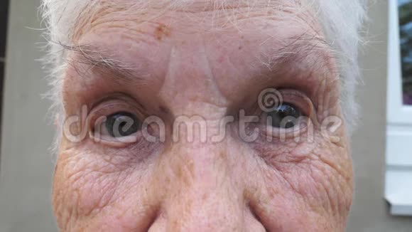 老奶奶满脸皱纹带着悲伤的目光看着镜头成熟女人的肖像视频的预览图