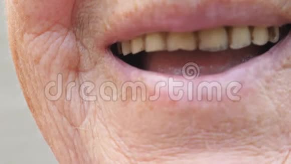 奶奶笑着闭上嘴露出发黄的牙齿一位满脸皱纹的老妇人在镜头前笑视频的预览图