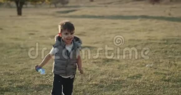 有趣可爱的小男孩跑在镜头前的中间视频的预览图