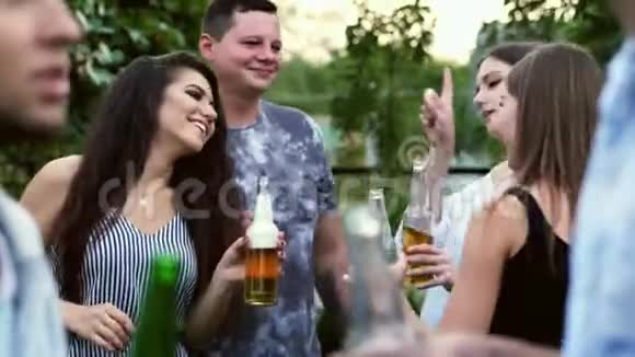 快乐的朋友跳舞叮当作响的瓶子和交谈人们在公园户外喝啤酒聚会视频的预览图