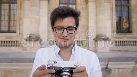 巴黎法国2019年4月在卢浮宫博物馆背景下穿着白色衬衫的年轻人用摄像机拍摄照片视频的预览图