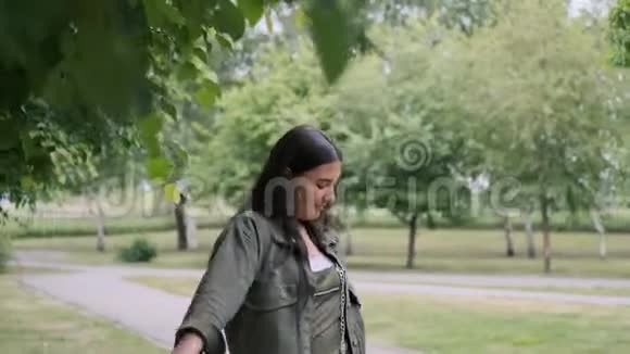欢快的时髦女孩在公园里用便携式音响扬声器对着音乐跳舞视频的预览图