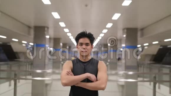 年轻英俊的亚洲男子双臂交叉在地铁站视频的预览图