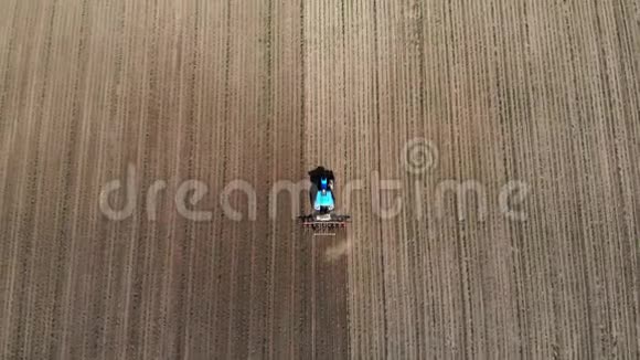 空中俯视大拖拉机带着一棵年轻的玉米穿过田野玉米行间加工过程视频的预览图