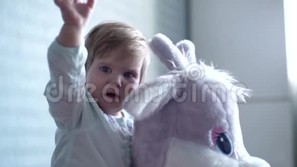 小女孩坐在一个柔软的大玩具旁边慢动作地哭得很近视频的预览图