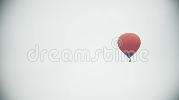 一个橙色的气球在白色的天空中飞行视频的预览图
