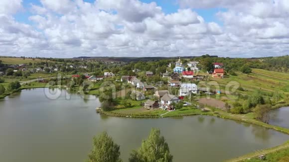 在湖边的一座山上鸟瞰美丽的村庄景观把摄像机移到主题上视频的预览图