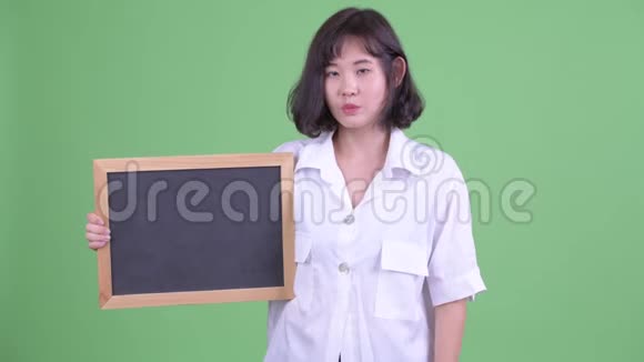 快乐的亚洲女商人拿着黑板竖起大拇指视频的预览图
