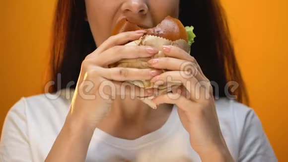 女人咬着美味的汉堡包对食物质量不满特写视频的预览图