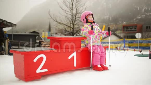 小滑雪者的肖像她坐在胜利者的讲台上可爱的孩子度过了许多有趣的寒假视频的预览图