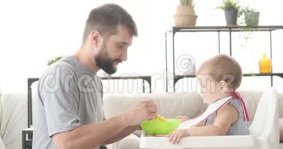 父亲喂养他可爱的宝贝女儿视频的预览图