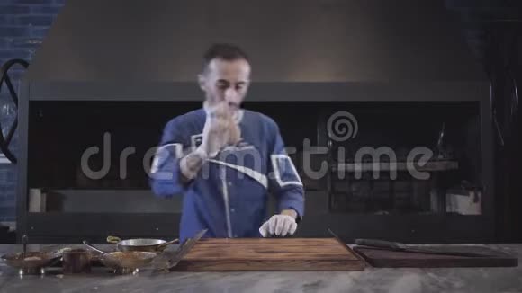 穿着蓝色厨师制服的熟练男子在现代餐厅为卢拉串肉准备生肉大型烤炉视频的预览图