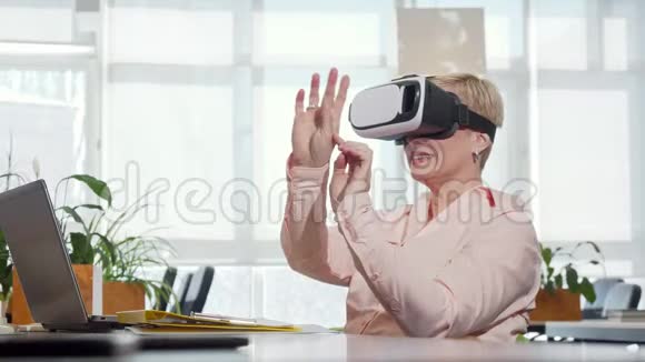 成熟的女商人在工作场所尝试3D虚拟现实眼镜视频的预览图