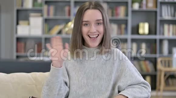 女青年在视频聊天中挥手的肖像视频的预览图