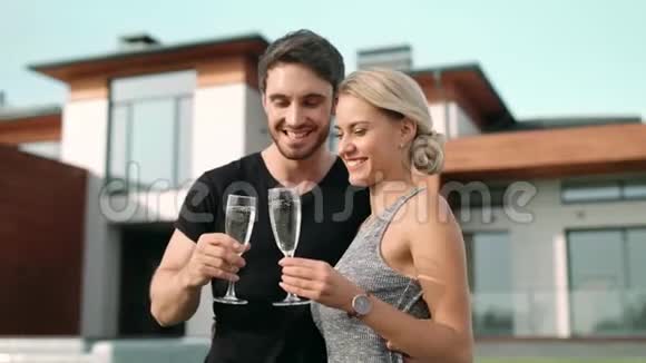 幸福的一对夫妇在豪宅附近喝香槟亲密情侣喝酒视频的预览图