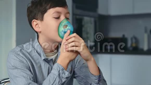 治疗哮喘男孩通过吸入器呼吸站在厨房里视频的预览图