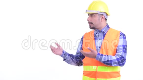 快乐的波斯人建筑工人一边说话一边展示东西视频的预览图