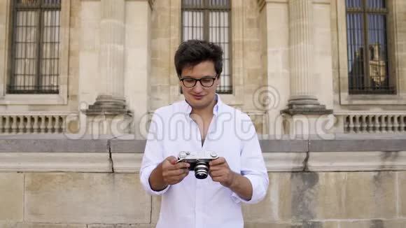 巴黎法国2019年4月在卢浮宫博物馆背景下穿着白色衬衫的年轻人用摄像机拍摄照片视频的预览图