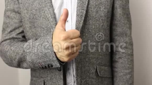 穿着灰色夹克和白色背景上有斑点的衬衫的纯白白种人把批准拇指拉起来良好的手势视频的预览图