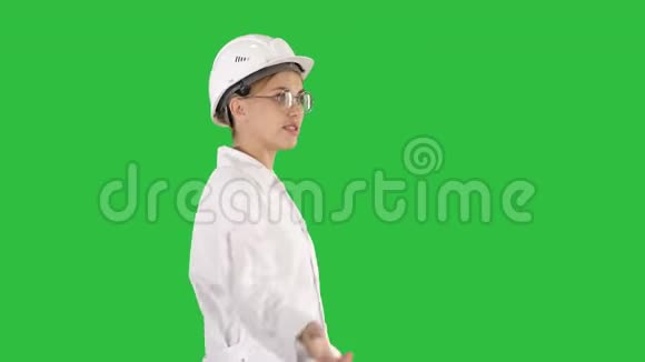 年轻的科学家穿着实验室外套戴着安全帽在绿色屏幕上走来走去说些什么Chroma键视频的预览图