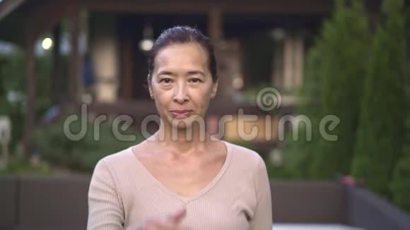 中年亚洲女人在外面竖起大拇指视频的预览图